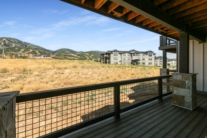 Outdoor balcony featuring dark composite decking and a metal grid railing
