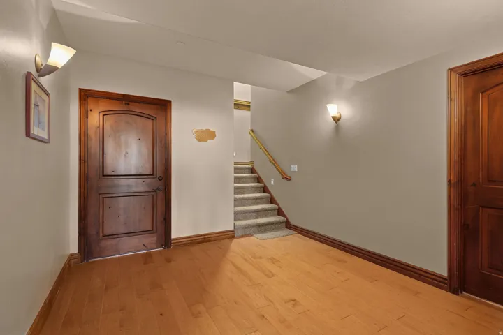 Downstairs entry with hardwood flooring extending through the entry, featuring solid wood doors and coordinating baseboards