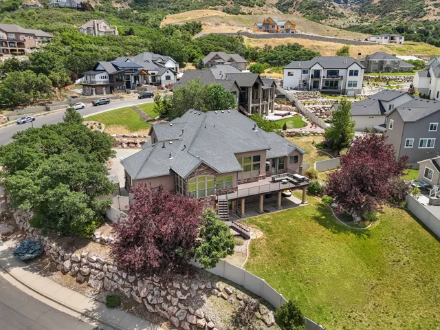 Expansive terraced backyard featuring a multi-level deck, stone retaining walls, and mature landscaping