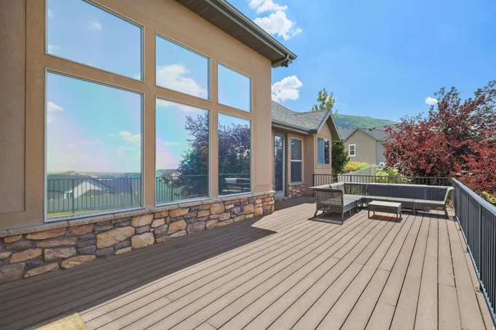 Expansive outdoor deck featuring wood-finish flooring and black metal railings