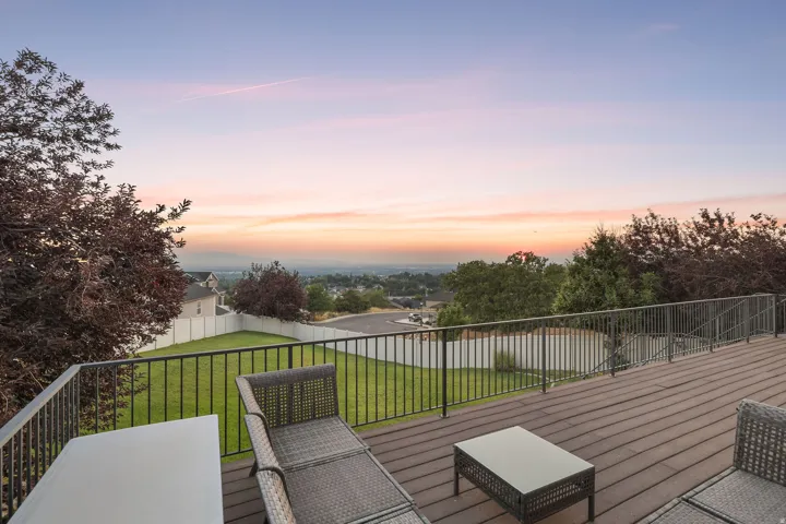 Expansive outdoor deck featuring composite wood-finish flooring and black metal railings