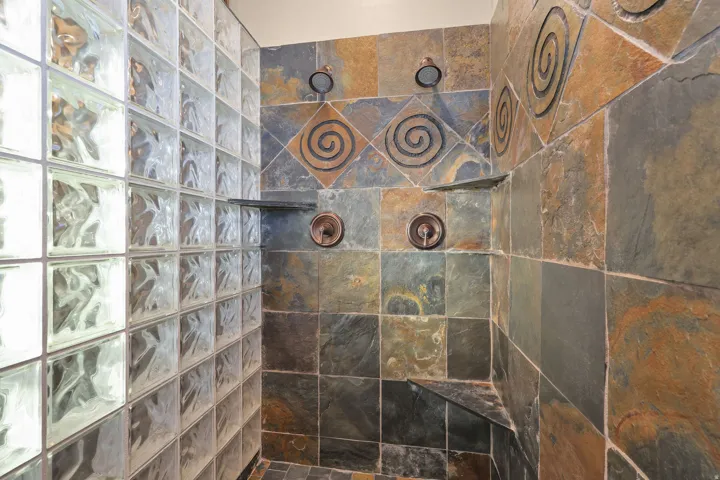 Shower enclosure with glass block wall and multi-toned slate tile
