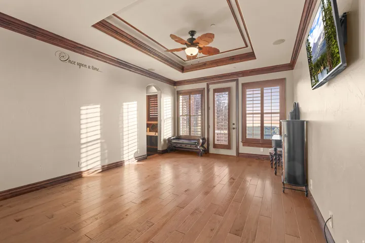 Hardwood flooring with a coffered ceiling featuring wood trim