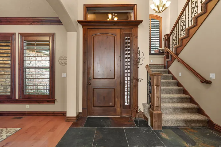 Entryway featuring a solid wood door with slate flooring, and hardwood flooring