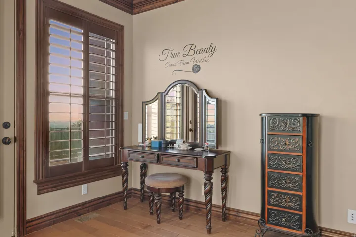 Wood-finish flooring with dark wood baseboards, window trim, and crown molding