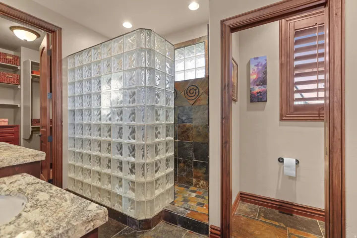 Glass block shower enclosure with a slate tile surround and floor