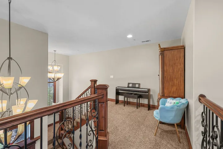 Upper-level landing featuring textured carpeting and light neutral wall paint