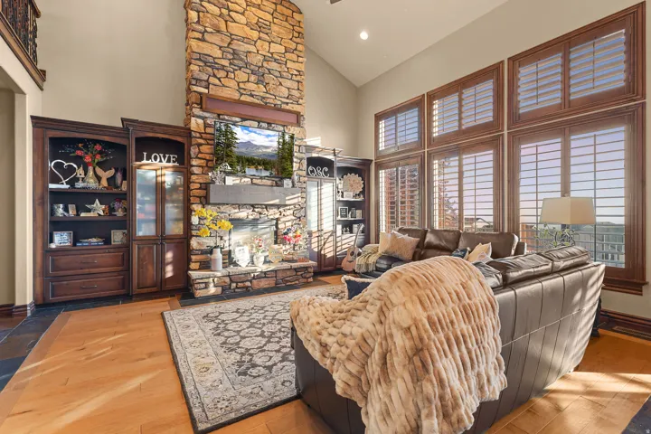 Two-story stone fireplace with a wood mantle and recessed lighting