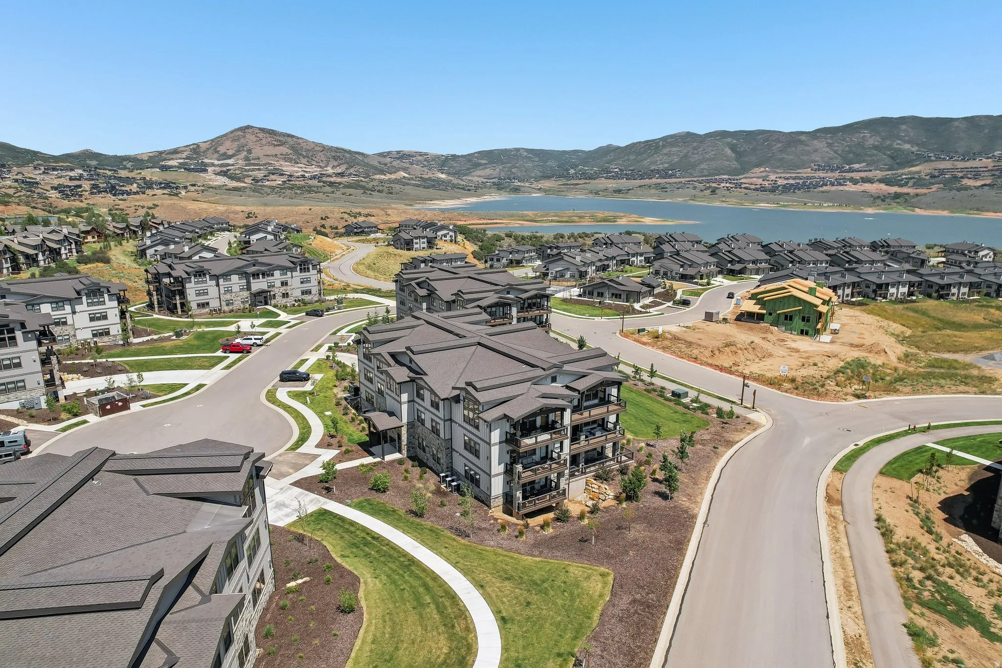 Modern multi-story residential buildings featuring dark roofing, stone, and siding exteriors
