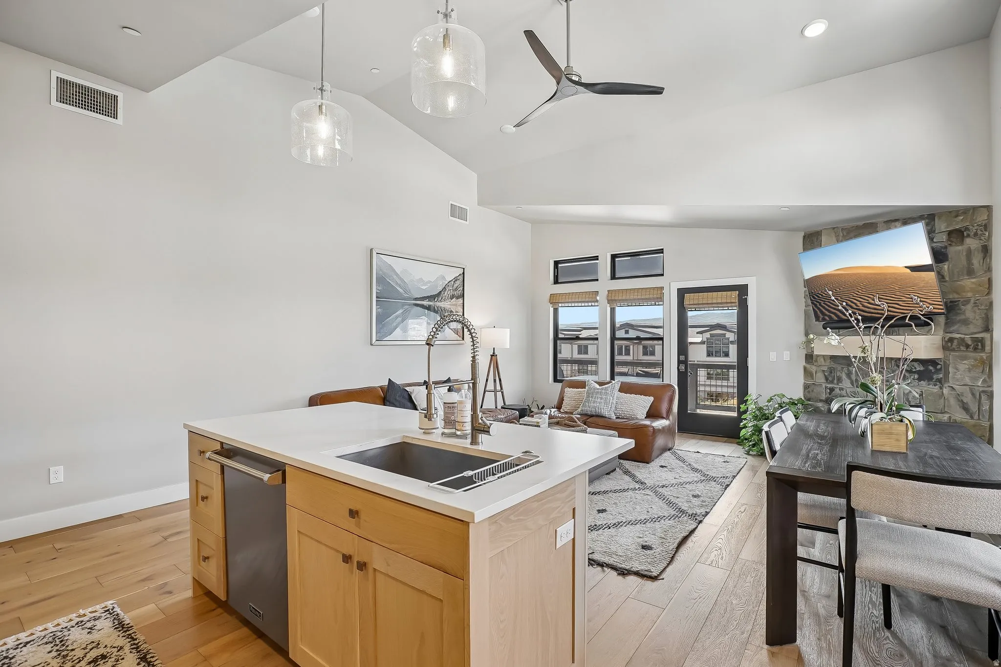 Open-concept living space featuring wood-finish flooring, a vaulted ceiling, and recessed lighting