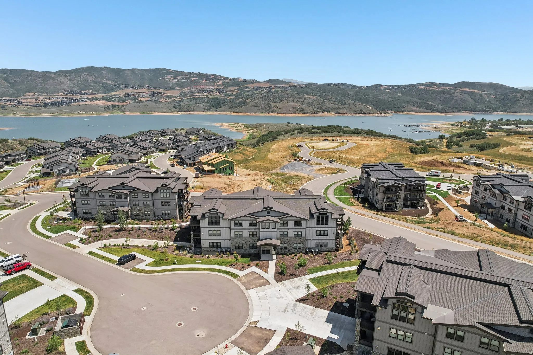 Community featuring contemporary multi-story residences with stone and siding exteriors, surrounded by landscaped grounds and paved roadways