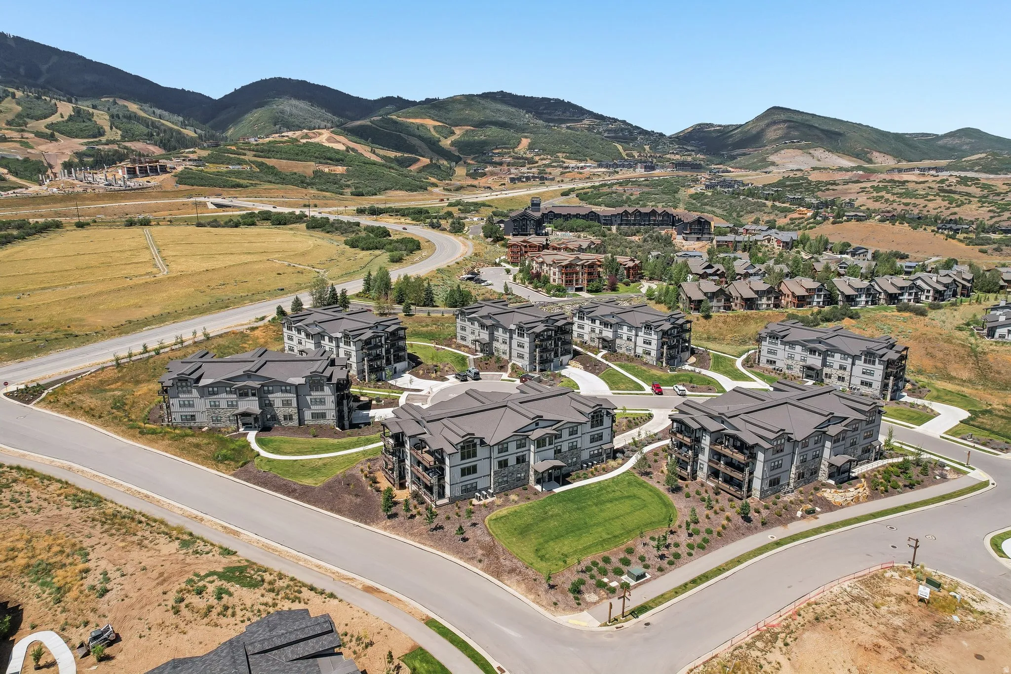 Contemporary multi-story buildings featuring dark roofs, light-colored facades, and integrated balconies