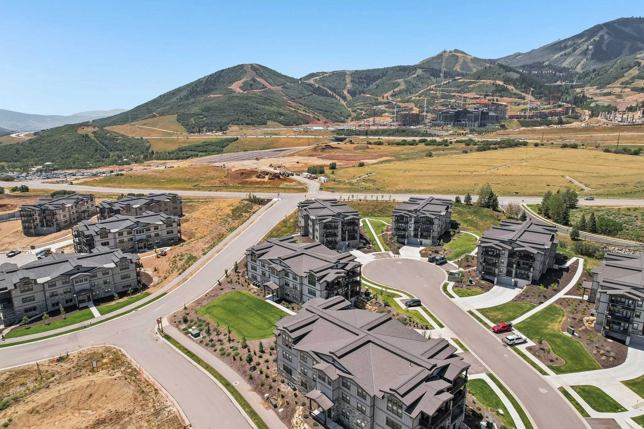 Aerial perspective showcasing a residential development with multiple multi-story buildings, paved roads, and landscaped areas