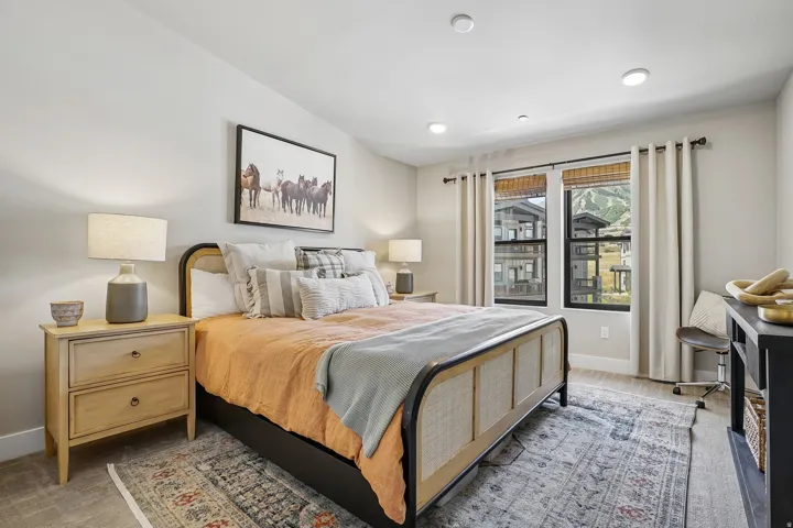 Bedroom featuring recessed lighting, a vaulted ceiling, wood-finish flooring, and two large windows with mountain scenery