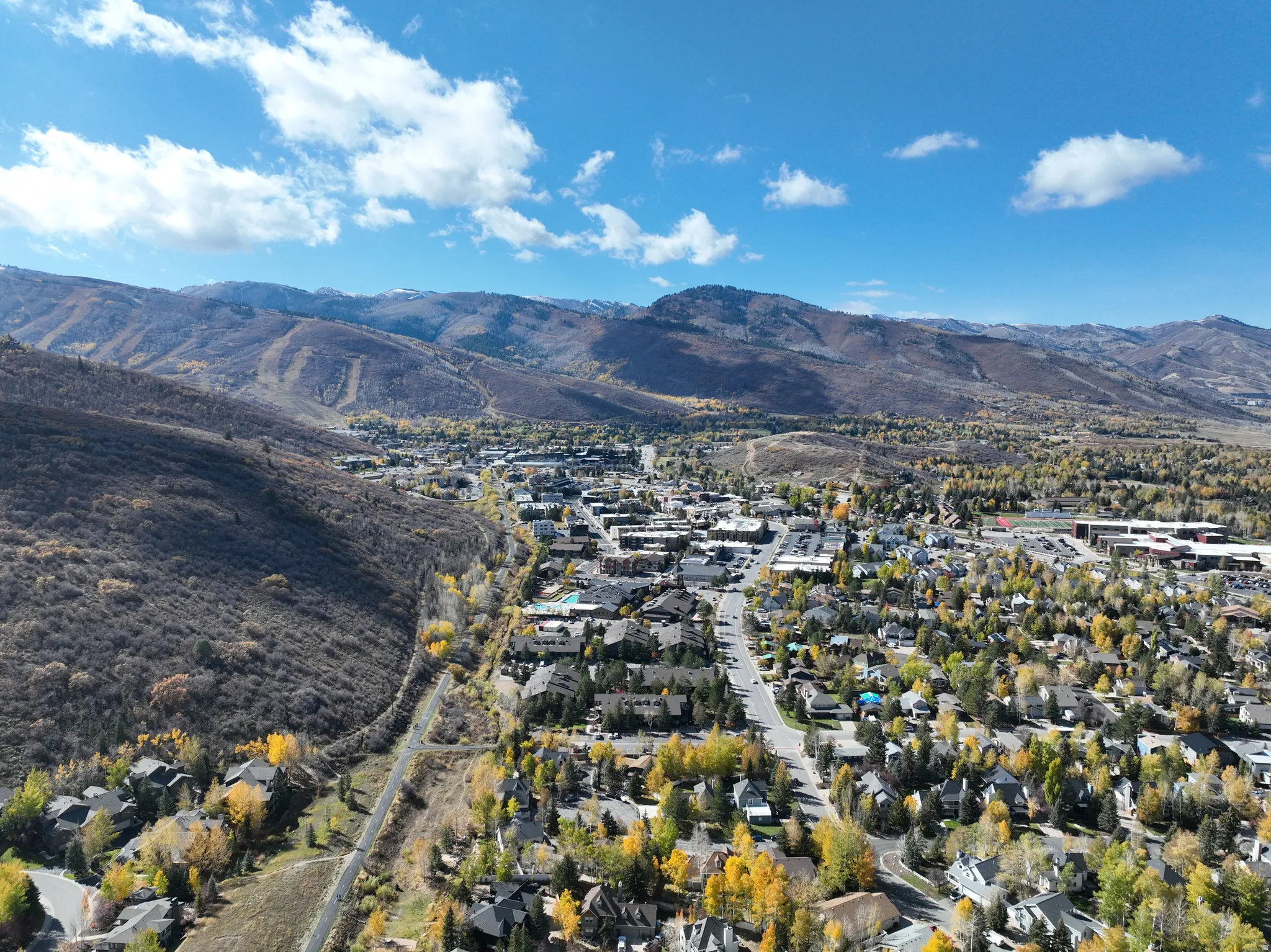 Expansive mountain landscape featuring a community with mature trees and paved roads