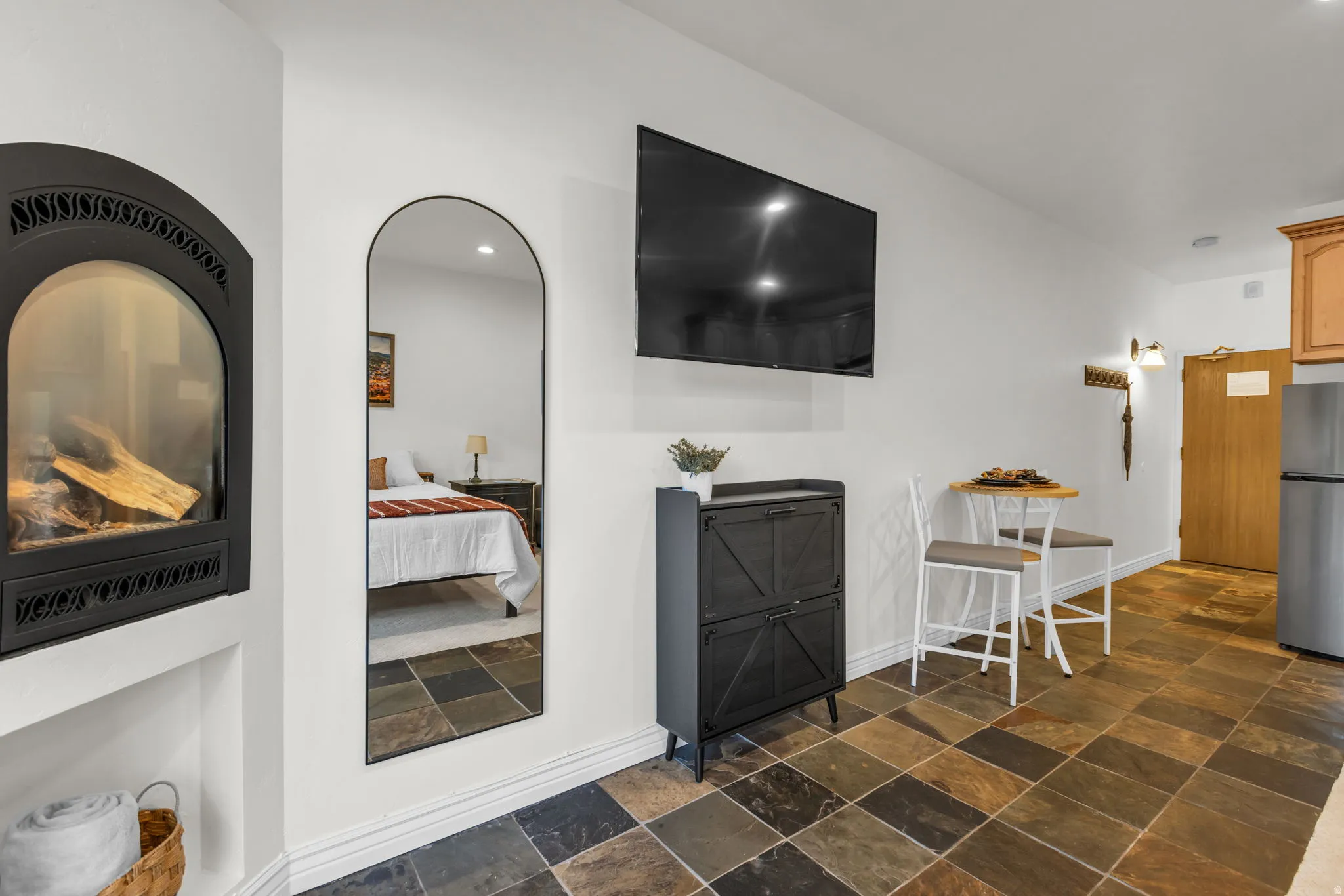 Stone tile flooring complemented by a built-in fireplace with a black iron facade