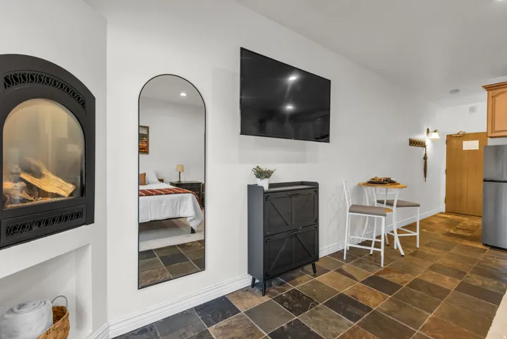 Stone tile flooring complemented by a built-in fireplace with a black iron facade
