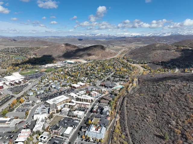 Aerial perspective showcasing a vibrant community with diverse architecture, surrounded by expansive natural landscapes