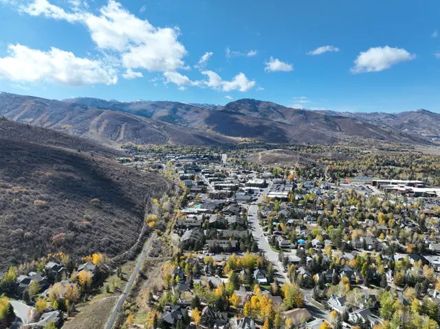 Expansive mountain landscape featuring a community with mature trees and paved roads