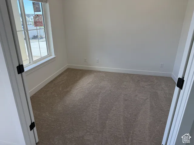 Carpeted flooring, white walls, white trim, and a double-pane window