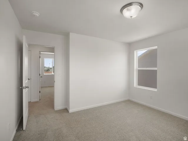 Room featuring light-colored carpeting, white walls, and a single window with a white frame