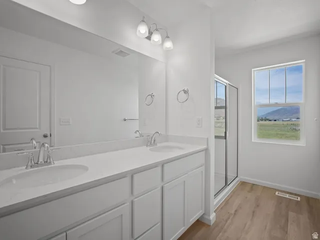 Bathroom featuring a double vanity with white cabinetry, light-toned countertops, and dual sinks