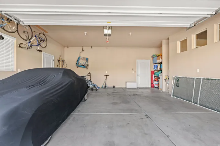 Spacious garage featuring a concrete floor, two entry doors, and high transom windows