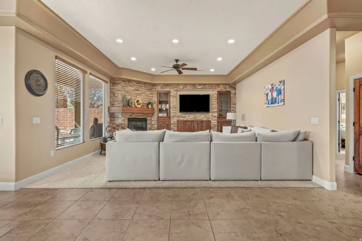 Living area featuring a stone accent wall with a fireplace and wood mantel