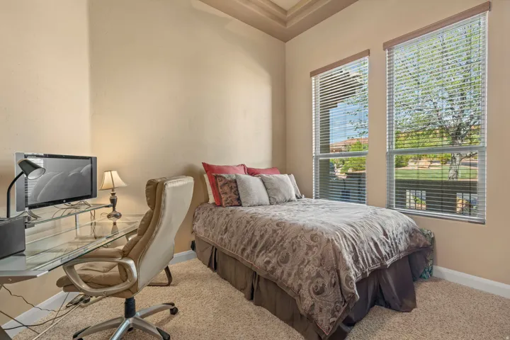 Interior room featuring a tray ceiling, two large windows with blinds, and beige wall paint