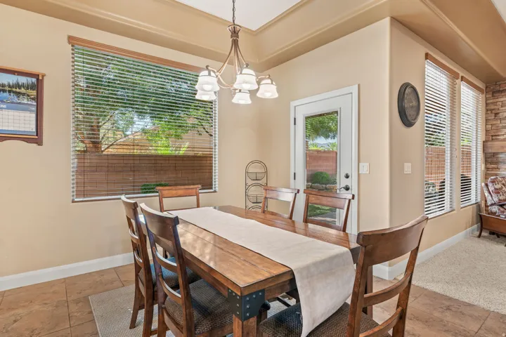 Dining area featuring tray ceiling, chandelier lighting, and tile flooring