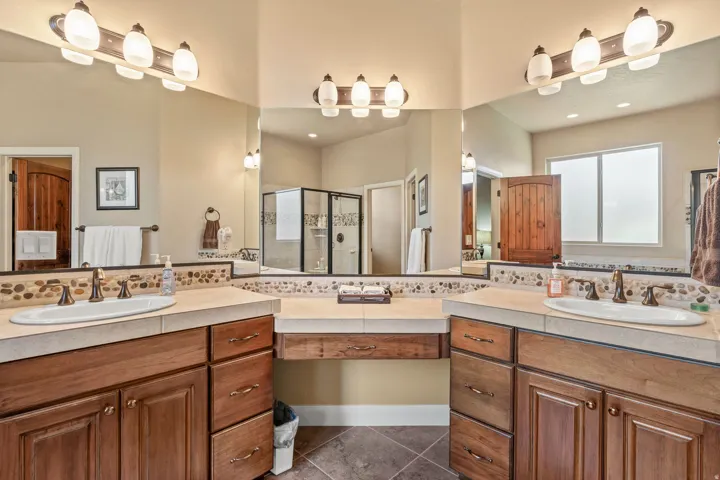 Double vanity with wood cabinetry, integrated sinks, and neutral countertops