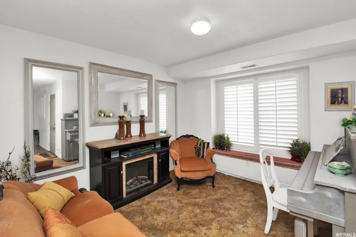 Recessed electric fireplace with a stone-finish hearth, flanked by built-in cabinetry