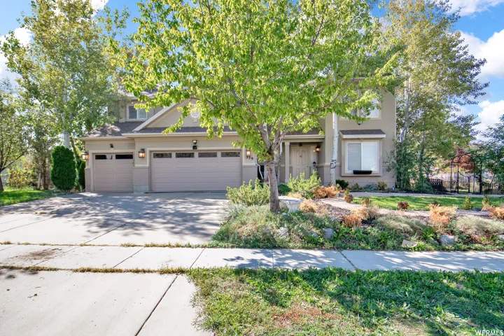 Two-story stucco residence with a multi-car garage and a concrete driveway