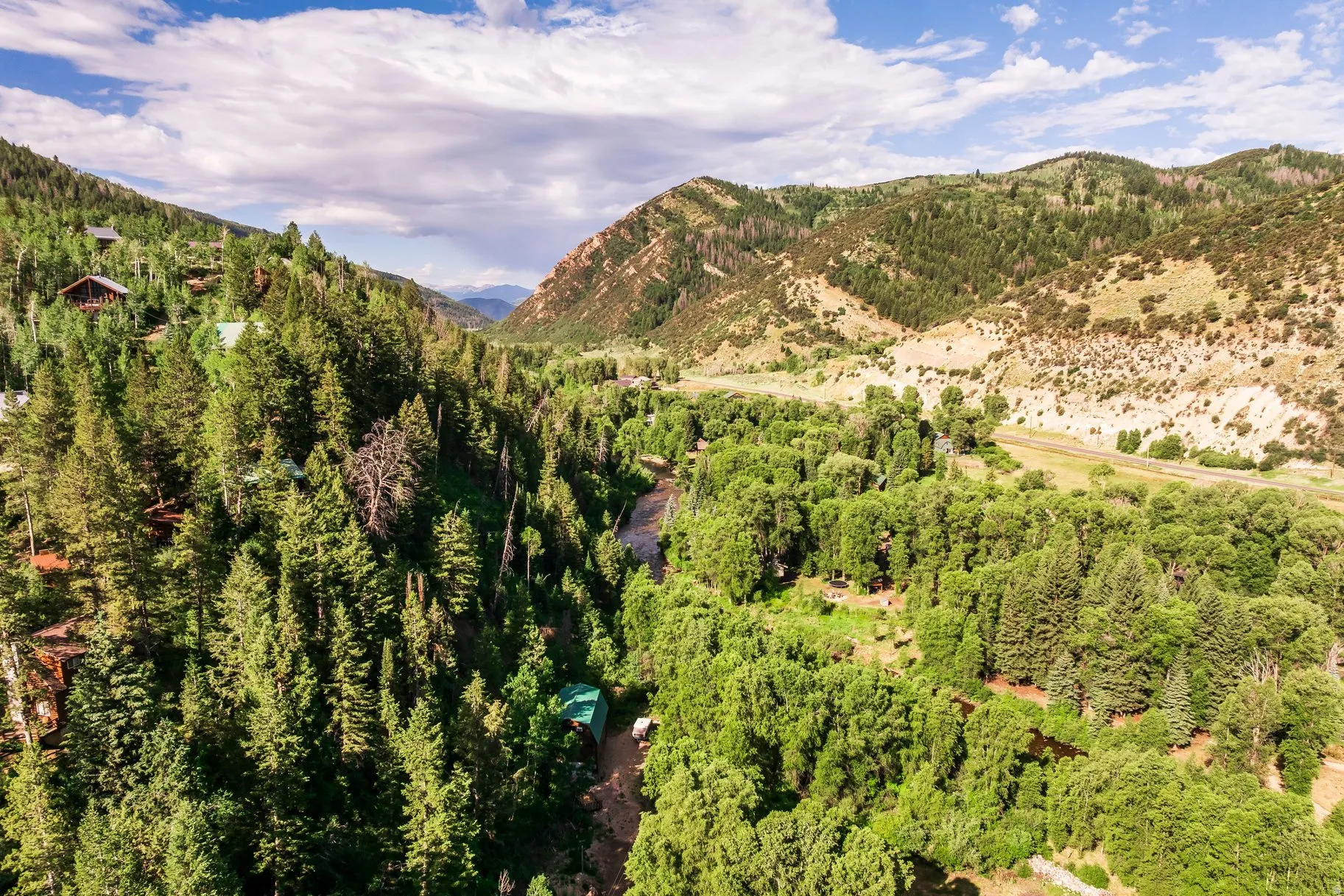 Mountainous landscape featuring dense forest and a winding river valley