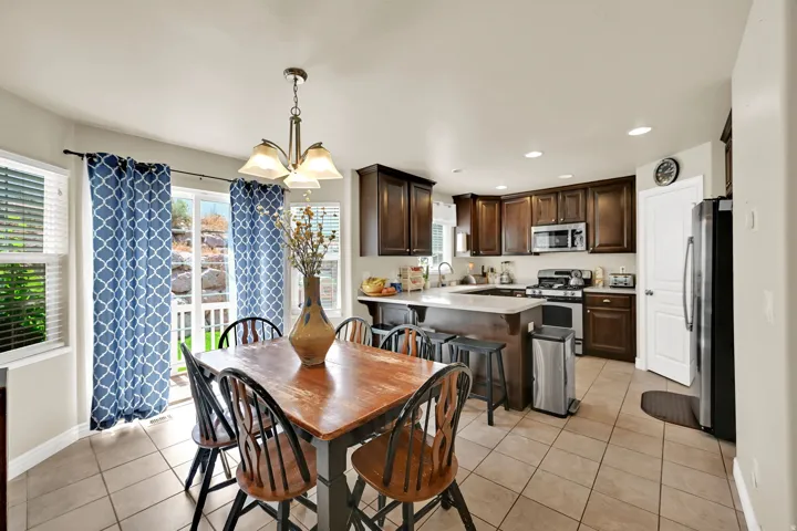 Kitchen featuring dark wood cabinetry, stainless steel appliances, and a central island with a light-toned countertop