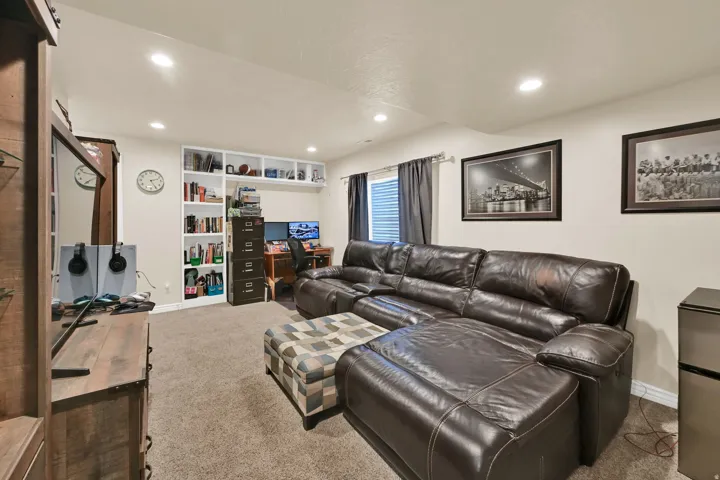 Finished interior space featuring recessed lighting, wall-to-wall carpeting, built-in shelving, a dedicated desk area, and a window with blinds