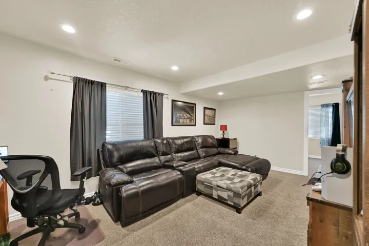 Carpeted living space featuring recessed lighting and white baseboards