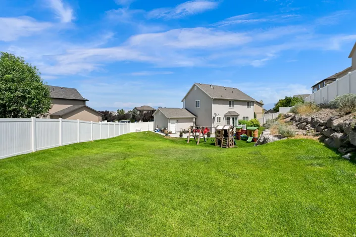 Expansive green lawn enclosed by a white privacy fence
