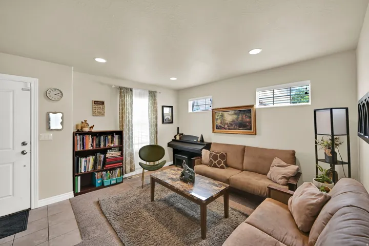 Living area with recessed ceiling lighting, two horizontal windows, and ceramic tile entry flooring