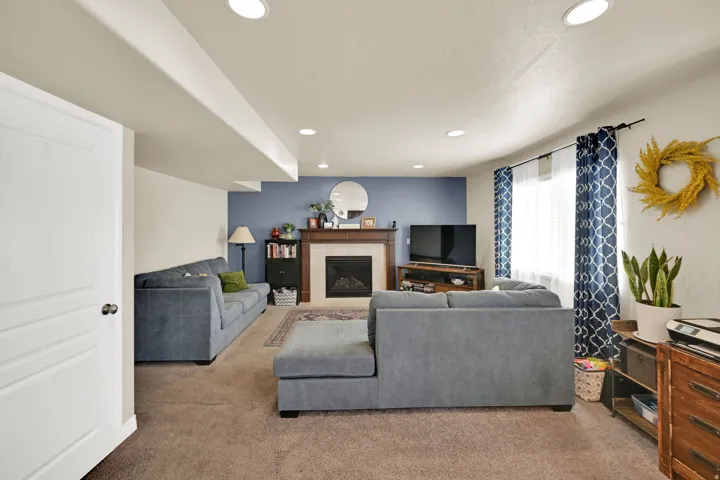 Living area featuring a fireplace with a wood mantle, a light-colored tile surround, and a dark hearth