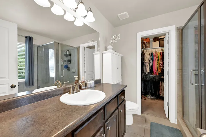 Bathroom featuring a single vanity with a white basin sink, bronze-finish faucet, and coordinating light fixture