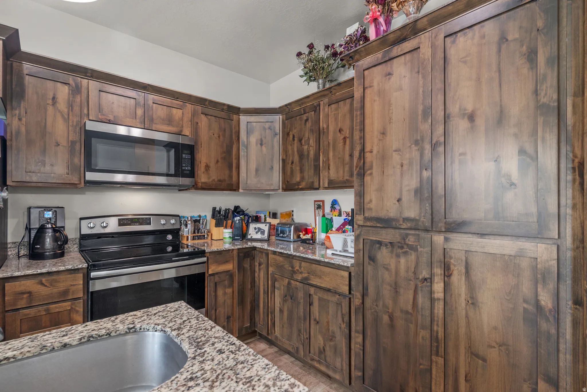 Kitchen featuring wood cabinetry, light-toned countertops, and stainless steel appliances