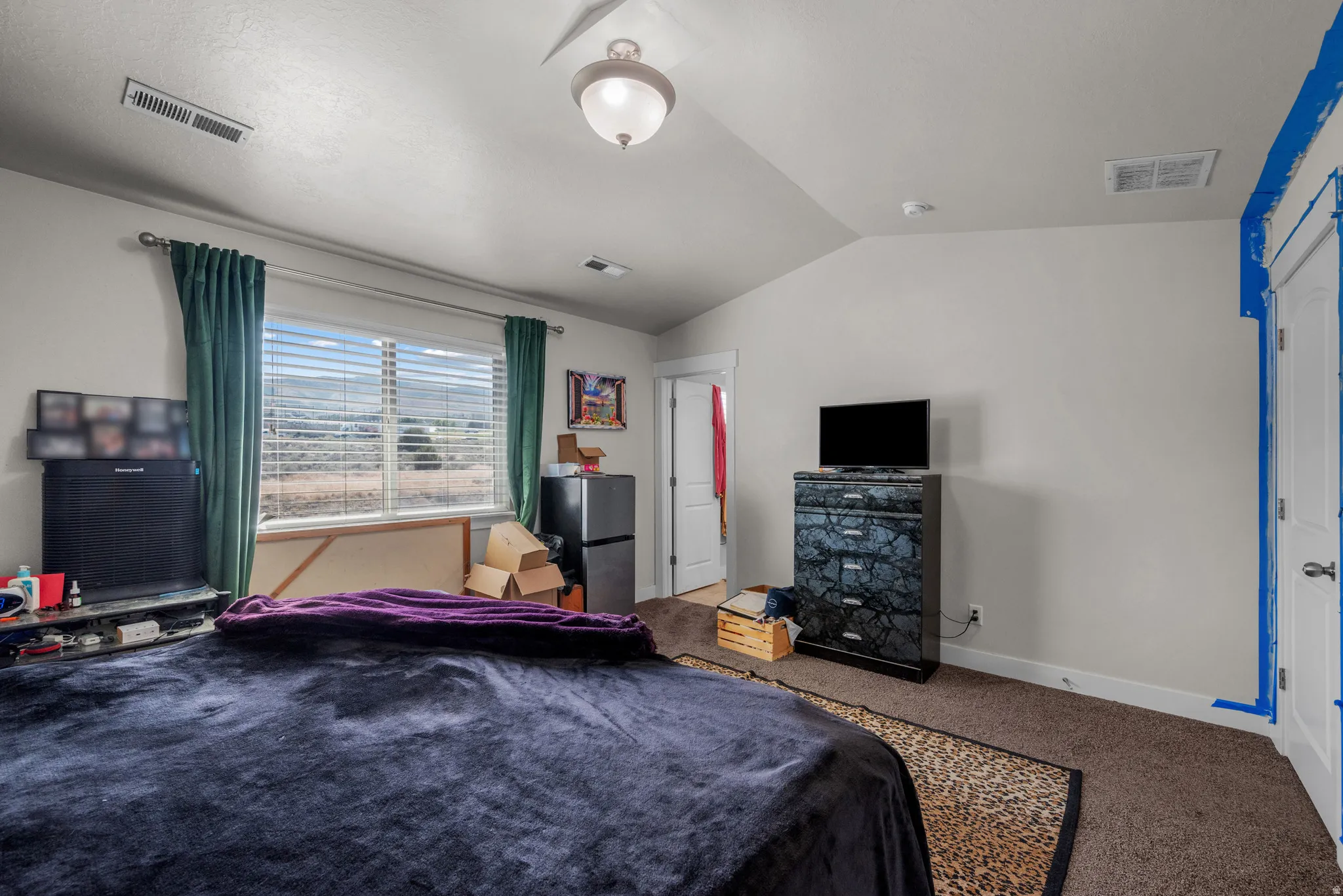 Carpeted room featuring a large window with horizontal blinds, a vaulted ceiling, and recessed lighting