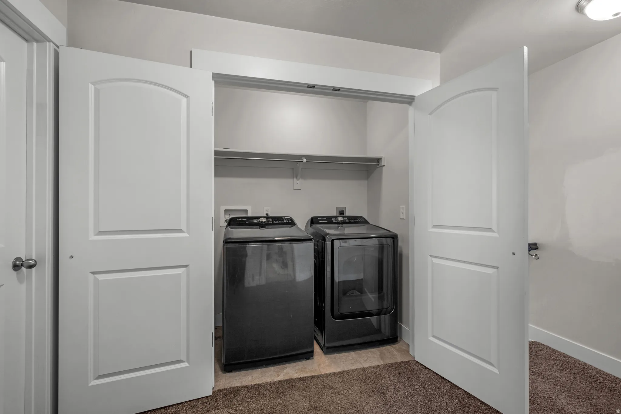 Dedicated laundry closet featuring a built-in shelf and hanging rod