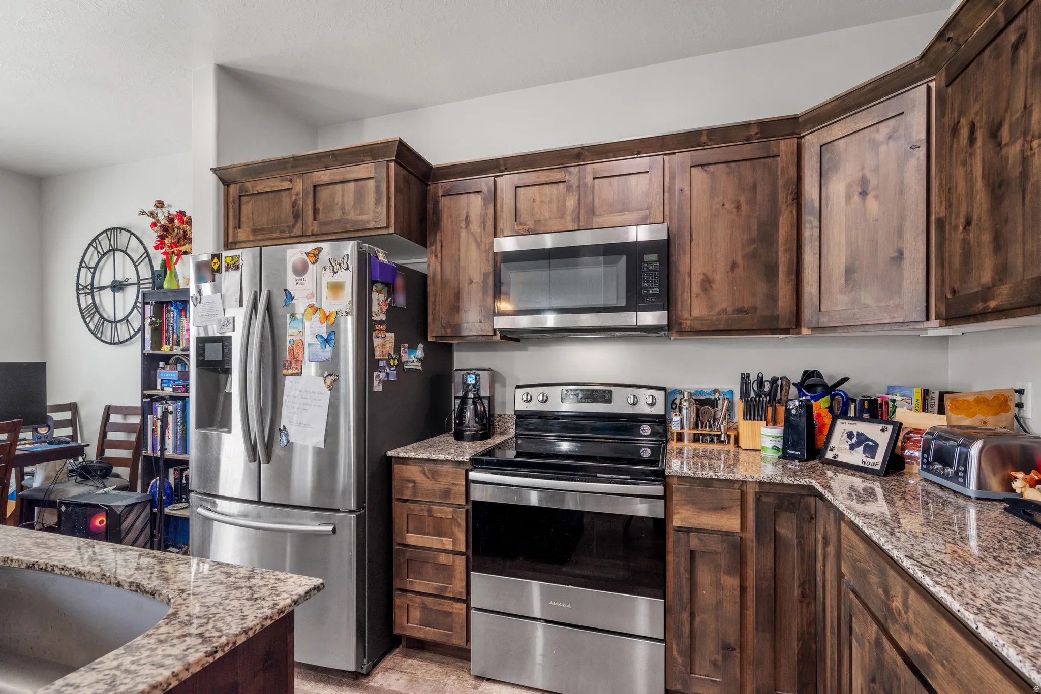 Kitchen featuring wood cabinetry, stainless steel appliances, and granite countertops