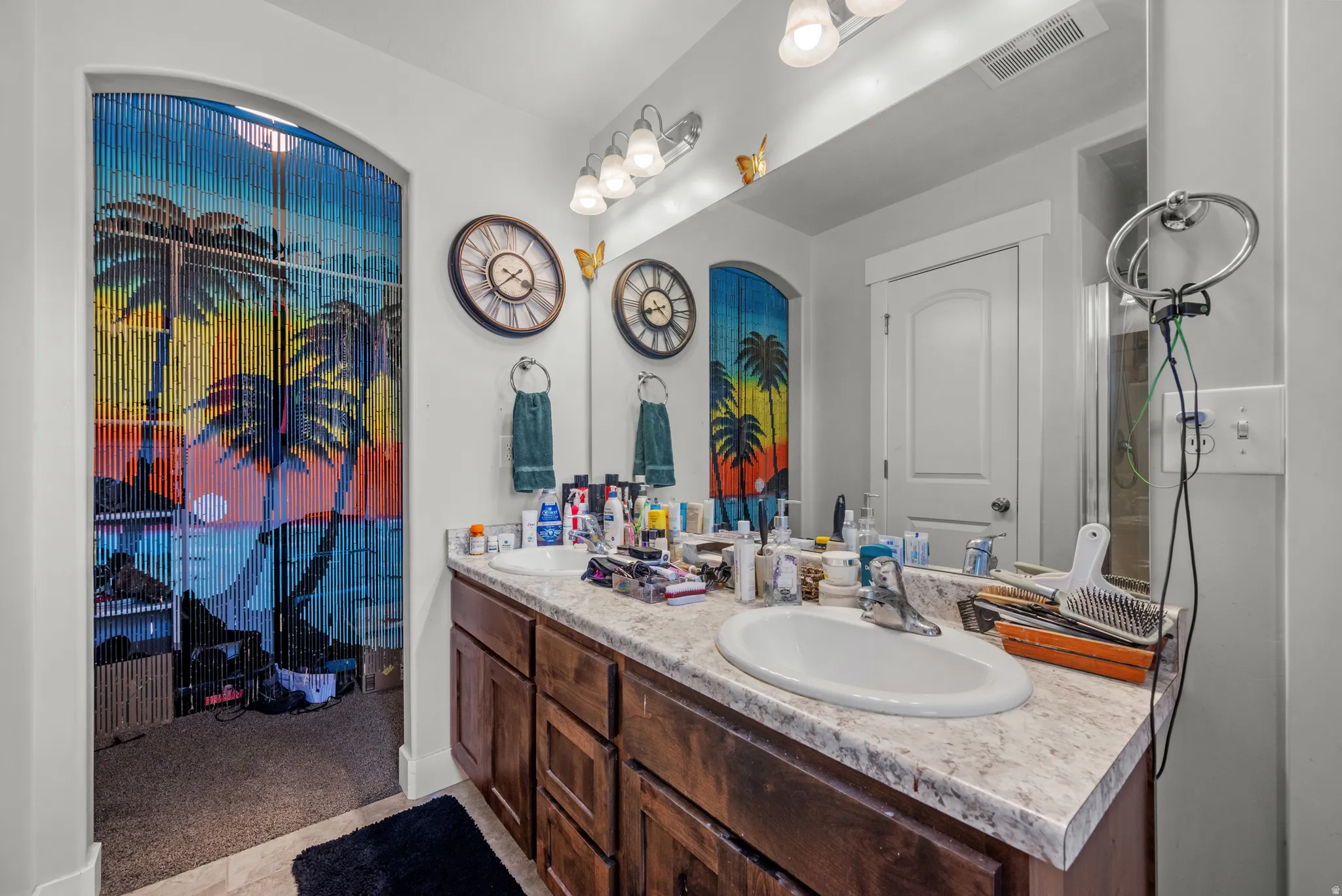 Double vanity with wood-finish cabinetry, light-colored countertop, and two undermount sinks