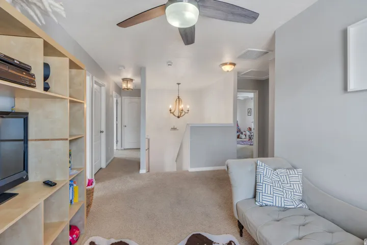 Carpeted loft area featuring a ceiling fan, recessed lighting, and built-in shelving