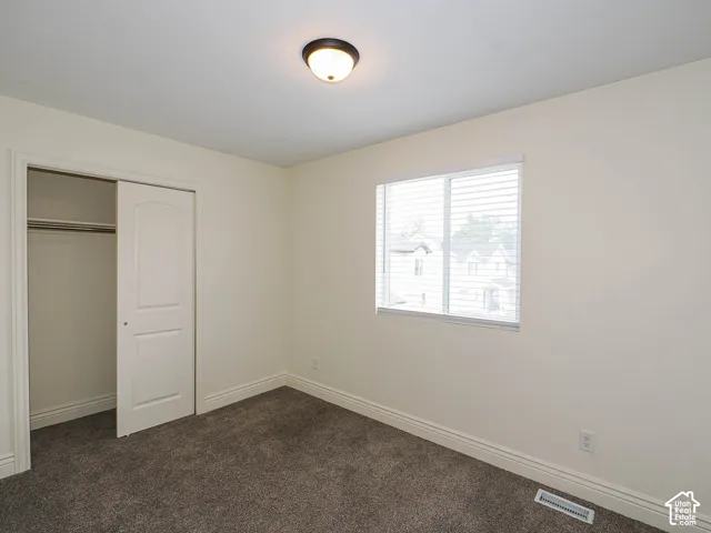 Neutral-toned walls complement the dark gray carpet flooring