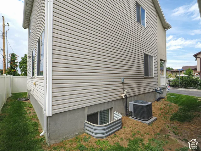 Horizontal siding exterior, multiple windows, foundation, white privacy fencing, and an HVAC unit