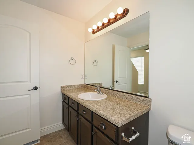 Dark wood-finish vanity with a light-toned countertop and an integrated sink